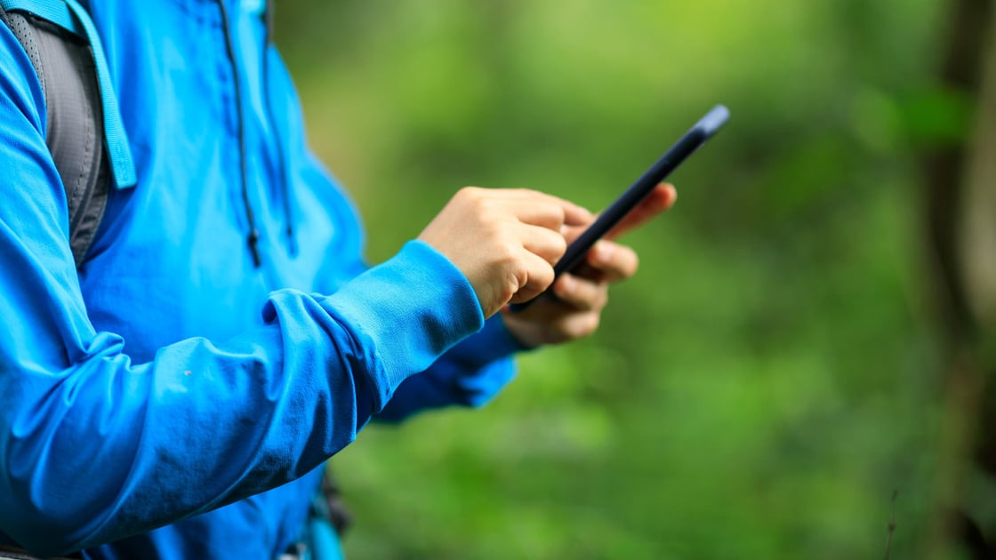 hiker-using-phone-blue-jacket